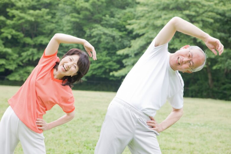 公園でラジオ体操をする老夫婦
