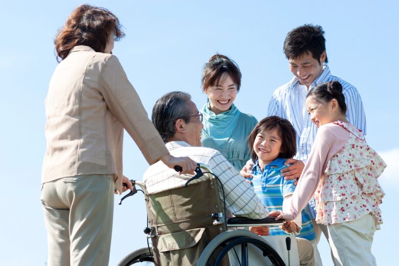 車椅子に座るシニア男性と笑顔の家族