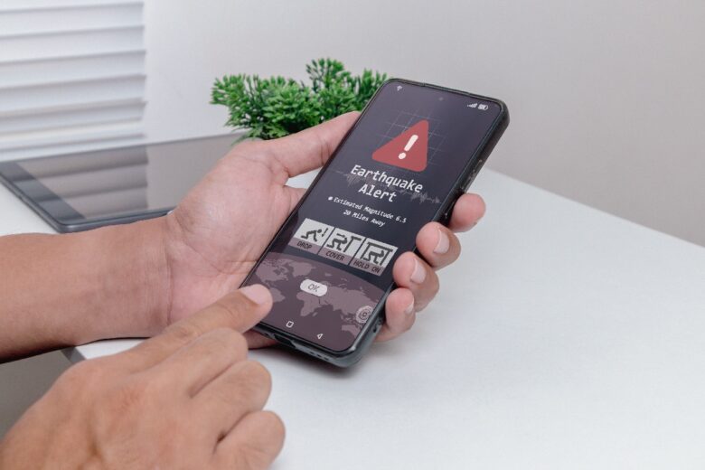Earthquake early warning system concept. Earthquake notification alert on smartphone with safety guide.
