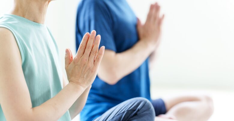 自宅でヨガをするミドル夫婦の手元