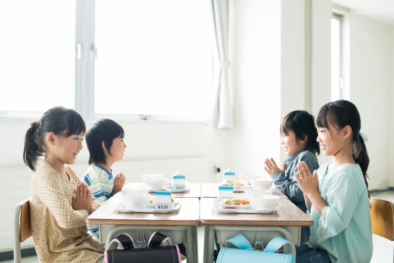 給食を前に手を合わせる小学生